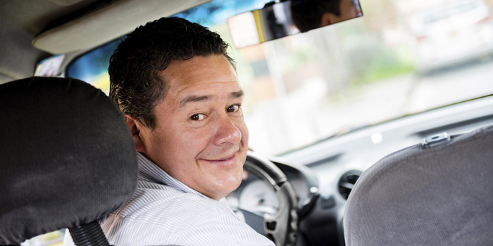 Hombre en su auto contento por comprar un carro usado