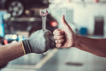 Técnico y cliente después de dar mantenimiento al carro