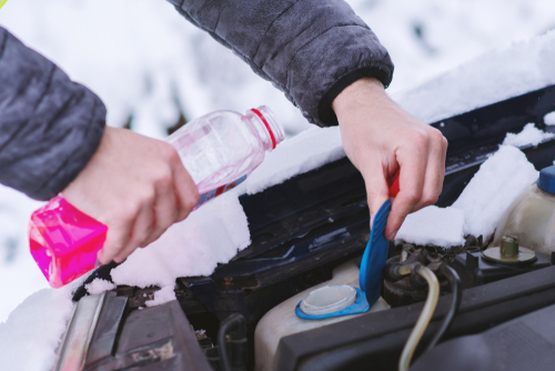 Persona usando liquido anticongelante para su auto