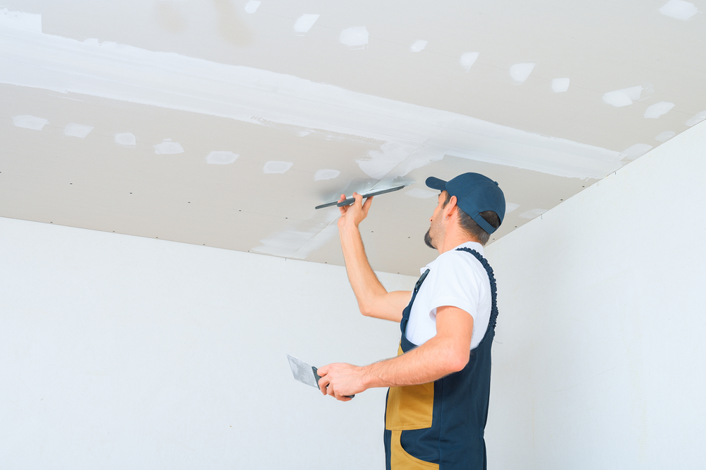 Hombre haciendo reparaciones en el techo de un departamento