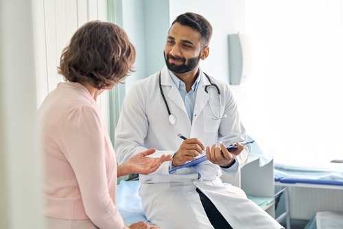 Personal médico hispano atendiendo a una mujer en su consultorio