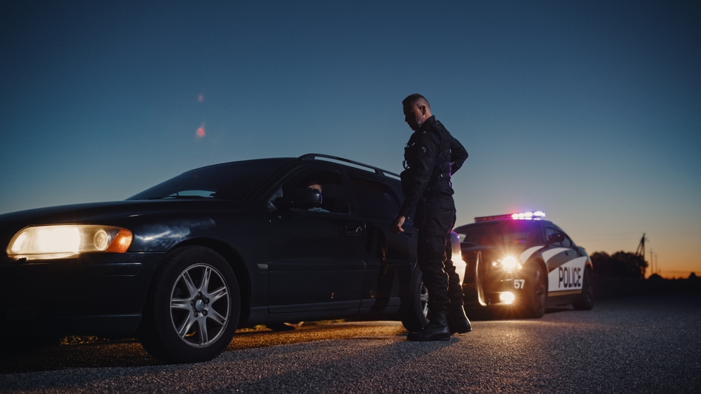 Policía deteniendo a un conductor en estado de ebriedad en la carretera