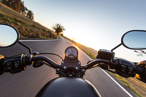 Conductor manejando su motocicleta mientras una aseguradora de motos protege su viaje