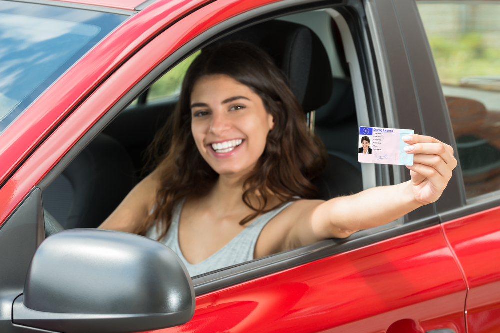 Mujer sonriendo por tener uno de los tipos de licencia de conducir