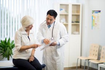 Doctor with a senior patient in an examining room.