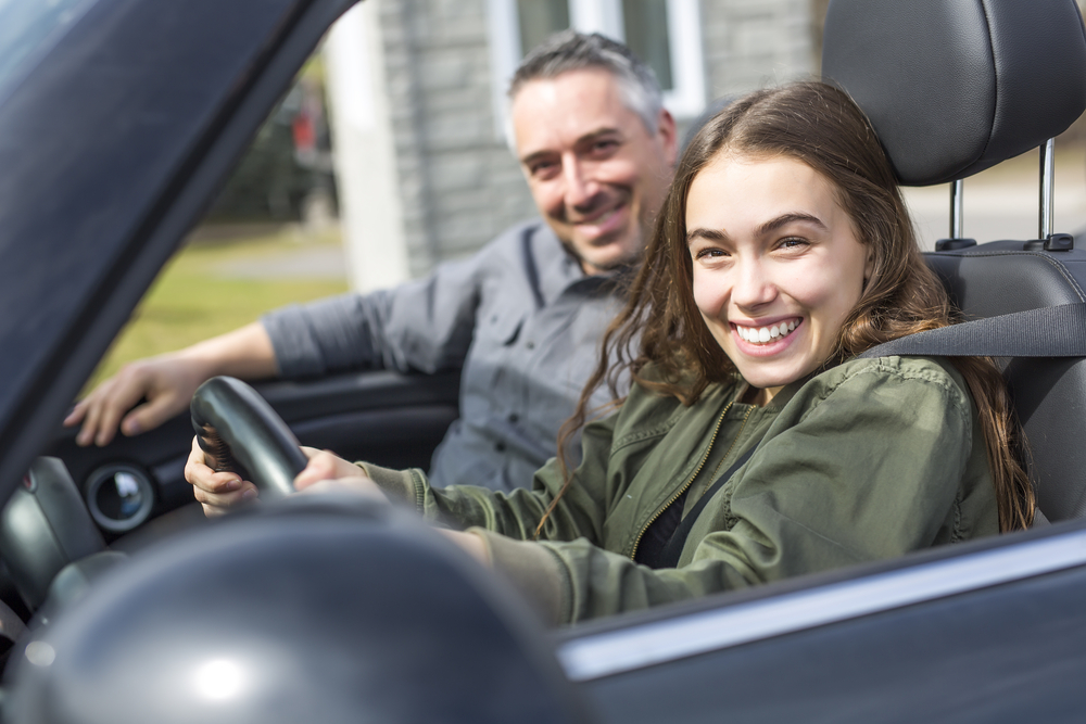 father helping teen daughter first time driving
