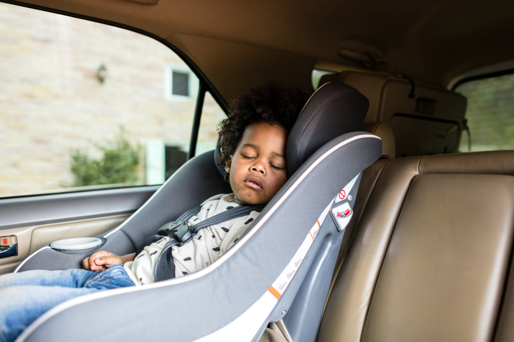 child sleeping on car seat with safety guidelines.