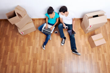 overhead view of couple sitting on floor together using computer