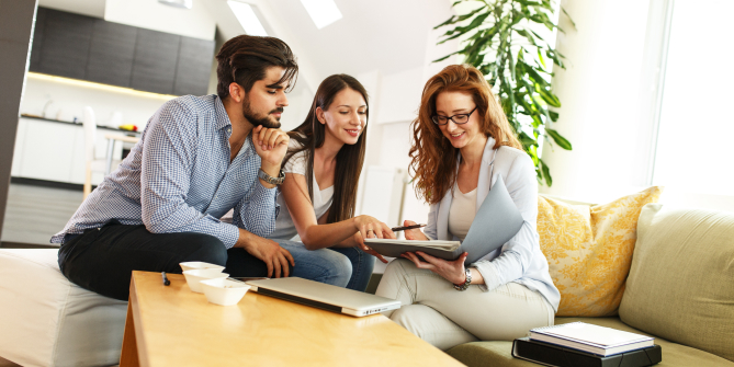 Young couple smiling and getting life insurance information from a qualified agent