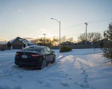 car driving on winter road in dallas during snow storm