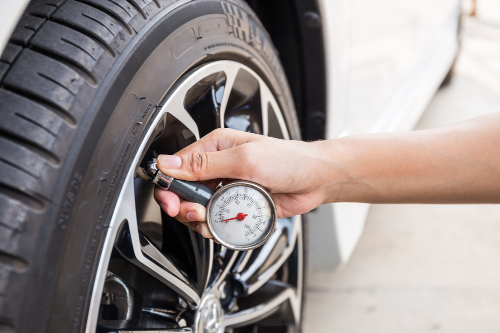 person checking tire pressure on tires
