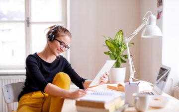 college student sitting at desk in apartment studying