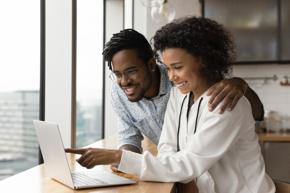 african american couple looking up life insurance on laptop