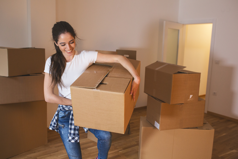 woman moving boxes into apartment