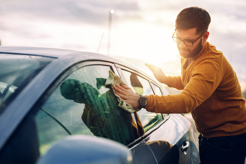 man cleaning exterior of car