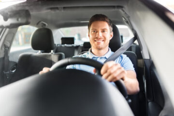 man driving in car with both hands on steering wheel