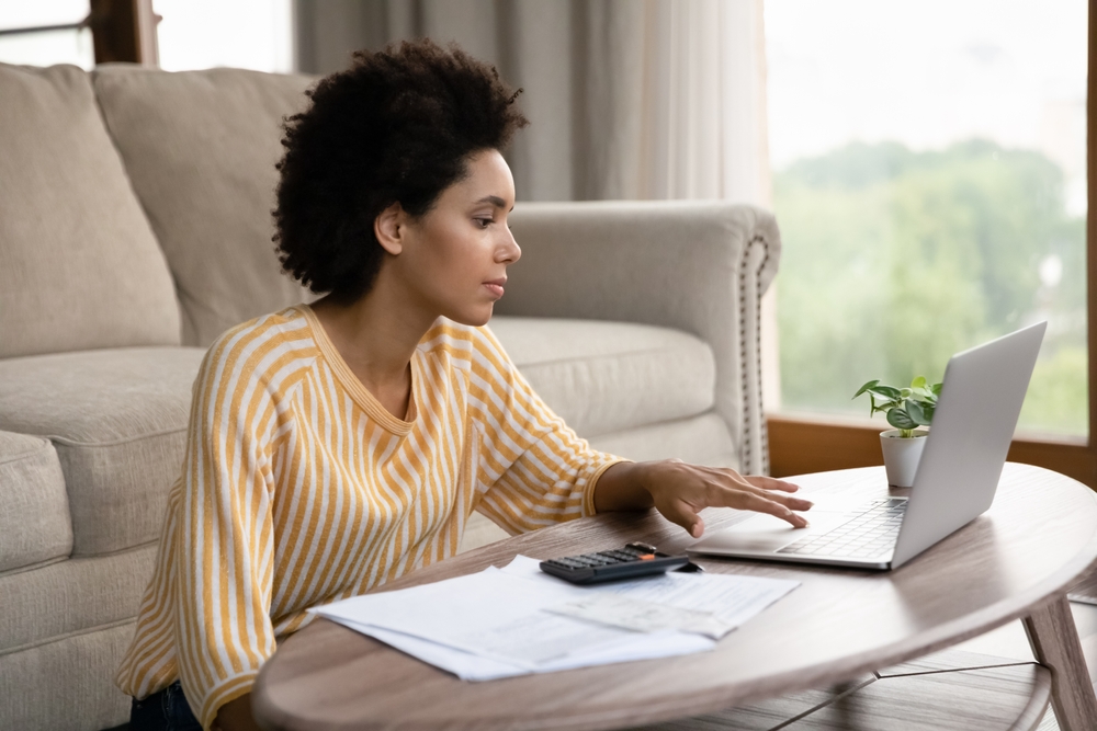 Young African American millennial checks her budget for renters insurance